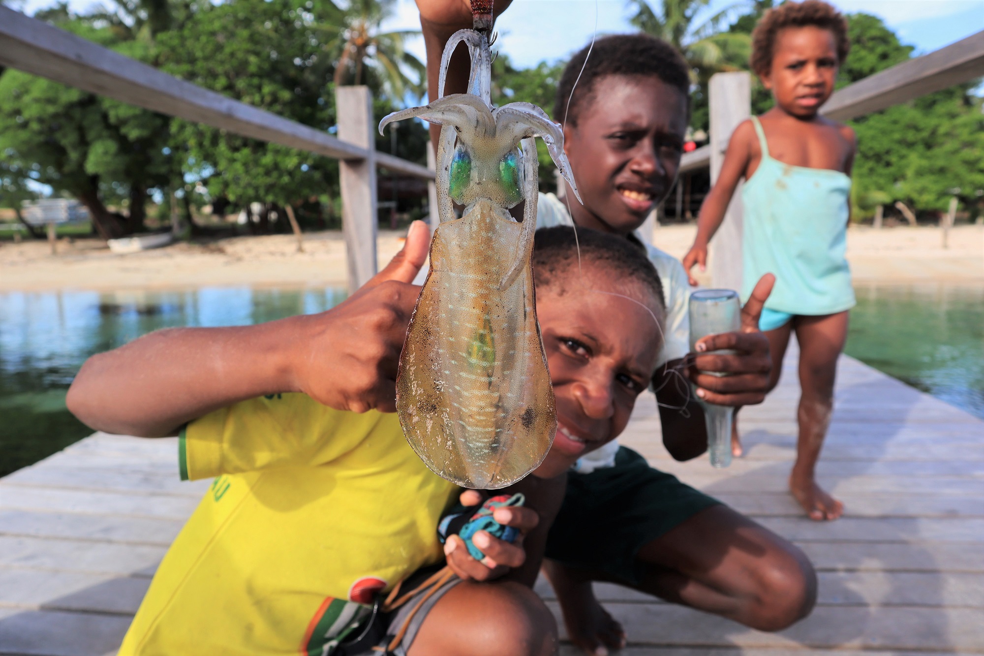 Fot. 2. Boys presenting a squid caught on a hook, Papua New Guinea (fot. Bart Napierala)